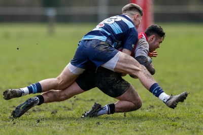 250323 - Cross Keys v Ystrad Rhondda - WRU Championship Cup Semi Final - McCauley Rowley of Ystrad Rhondda tackles Adam Tetley of Cross Keys 