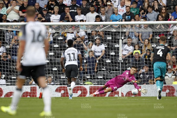100819 - Derby County v Swansea City, Sky Bet Championship - Freddie Woodman of Swansea City (right) saves a penalty from Florian Jozefzoon of Derby County