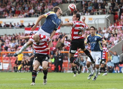 16.08.08...Doncaster Rovers v Cardiff City, Coca Cola Championship. -  Cardiff's Roger Johnson climbs above Doncaster's Gareth Roberts and Doncaster's Sam Hird  to head at goal 