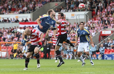 16.08.08...Doncaster Rovers v Cardiff City, Coca Cola Championship. -  Cardiff's Roger Johnson climbs above Doncaster's Gareth Roberts and Doncaster's Sam Hird  to head at goal 