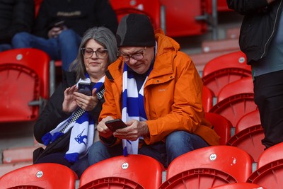 280226 - Doncaster Rovers v Cardiff City - Sky Bet League 1 - Cardiff fans look at their phones 