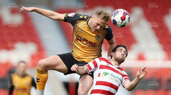 220423 - Doncaster Rovers v Newport County - Sky Bet League 2 - Cameron Norman of Newport County leaps up to head the ball from Aidan Barlow of Doncaster Rovers