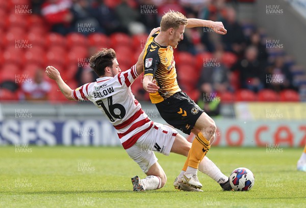 220423 - Doncaster Rovers v Newport County - Sky Bet League 2 - Harry Charsley of Newport County is tackled from behind by Aidan Barlow of Doncaster Rovers