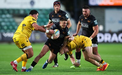 251025 - Newport RFC v Ospreys, United Rugby Championship - Reuben Morgan-Williams of Ospreys takes on Chris Coleman of Dragons and Tinus de Beer of Dragons