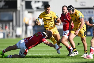 031026 - Dragons RFC v Scarlets - United Rugby Championship - Rio Dyer of Dragons is challenged by Kemsley Mathias of Scarlets