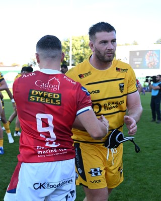 031026 - Dragons RFC v Scarlets - United Rugby Championship - Dane Blacker of Scarlets and Rhodri Jones of Dragons at full time