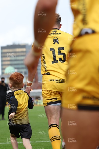 130925 - Dragons RFC v Scarlets - Preseason Friendly - Angus O’Brien of Dragons runs out with the mascot