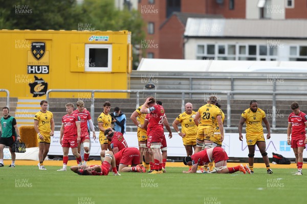130925 - Dragons RFC v Scarlets - Preseason Friendly - Scarlets players lie dejected at the final whistle 