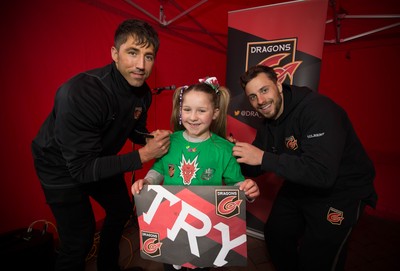 200218 - Dragons players Gavin Henson and Dorian Jones as they sign a tee shirt for Adie Moore, 8, from Ebbw Vale as they meet fans at Festival Park, Ebbw Vale