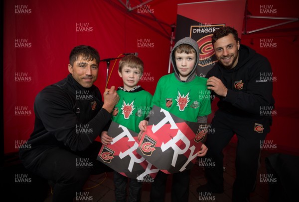 200218 - Dragons players Gavin Henson and Dorian Jones as they sign the tee shirts of Thomas and Riley Davies and 8 and 7 from Tredegar as they meet fans at Festival Park, Ebbw Vale