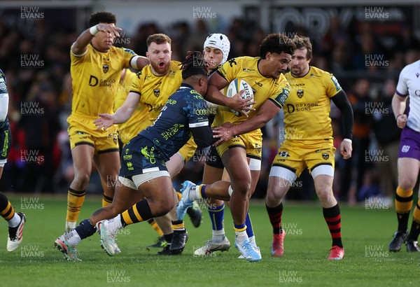 280226 - Dragons RFC v Benetton Rugby - United Rugby Championship - Fine Inisi of Dragons is tackled by Paolo Odogwu of Benetton Rugby 