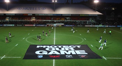 261213 - Newport Gwent Dragons v Cardiff Blues, RaboDirect PRO12 - Dragons and Blues players warm up as protest banner is placed on the pitch before the start of the match