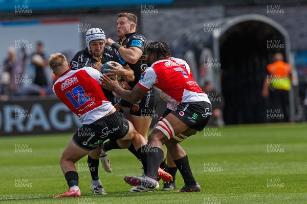 210522 - Dragons v Emirates Lions - United Rugby Championship - Ollie Griffiths of Dragons is tackled by Matt More and Vincent Tshituka of Emirates Lions