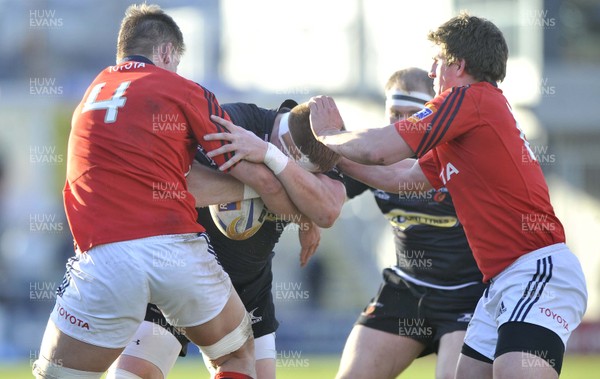 190413 - Newport Gwent Dragons v Munster - RaboDirect PRO12 -  Dragons Andrew Coombs, centre, is tackled by MunstersDavid Foley, left, and Ian Keatley