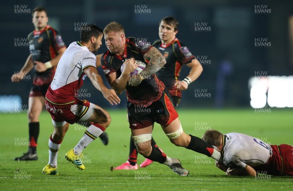 191018 - Dragons v Northampton Saints, European Challenge Cup - Ross Moriarty of Dragons is tackled by Jamie Gibson of Northampton Saints and Alex Mitchell of Northampton Saints