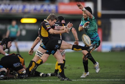 27.03.10 - Newport-Gwent Dragons v Ospreys - Magners League - Wayne Evans of Newport-Gwent Dragons kicks the ball past Mike Phillips of Ospreys. 