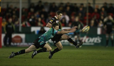 27.03.10 Dragons v Ospreys... Dragons' Jason Tovey kicks under pressure from Dan Biggar. 