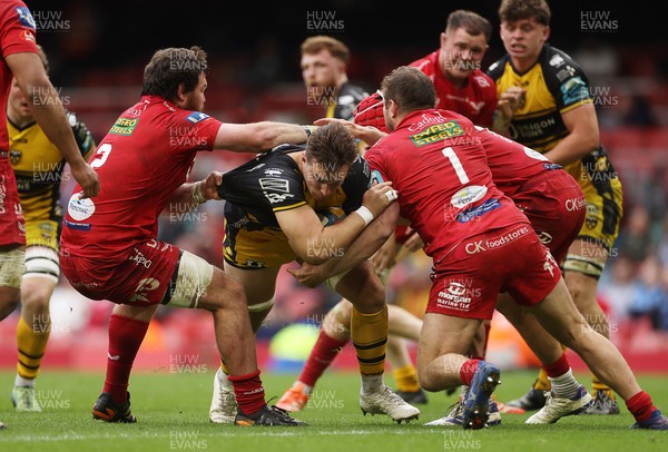 190425 - Dragons v Scarlets - Judgement Day X - United Rugby Championship - Taine Basham of Dragons is tackled by Marnus van der Merwe and Alec Hepburn of Scarlets 