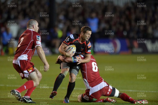 200913 - Dragons v Scarlets - RaboDirect PRO12Jason Tovey of Dragons, centre, is tackled by Aaron Shingler of Scarlets  (c) Huw Evans Picture Agency