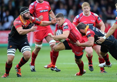 210815 - Newport Gwent Dragons v Scarlets, Pre-Season Friendly match - Scarlets Steven Shingler is tackled by Dragons Charlie Davies, and Cory Hill, left