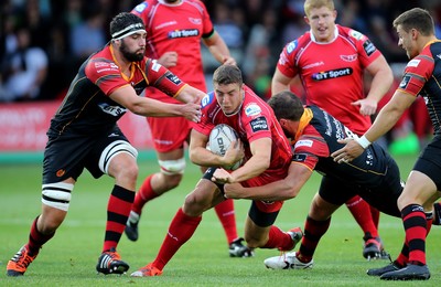 210815 - Newport Gwent Dragons v Scarlets, Pre-Season Friendly match - Scarlets Steven Shingler is tackled by Dragons Charlie Davies, and Cory Hill, left