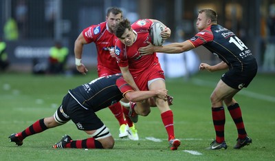 210815 - Newport Gwent Dragons v Scarlets, Pre-Season Friendly match - Scarlets Steffan Evans is tackled by Dragons Cory Hill and Tom Prydie