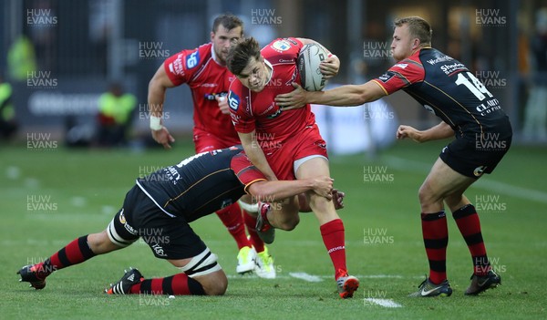 210815 - Newport Gwent Dragons v Scarlets, Pre-Season Friendly match - Scarlets Steffan Evans is tackled by Dragons Cory Hill and Tom Prydie