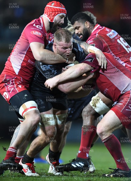 211219 - Dragons v Scarlets - Guinness PRO14 - Ross Moriarty of Dragons is tackled by Blade Thomson and Ken Owens of Scarlets