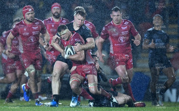 211219 - Dragons v Scarlets - Guinness PRO14 - Aaron Shingler of Scarlets is tackled by Jack Dixon and Sam Davies of Dragons