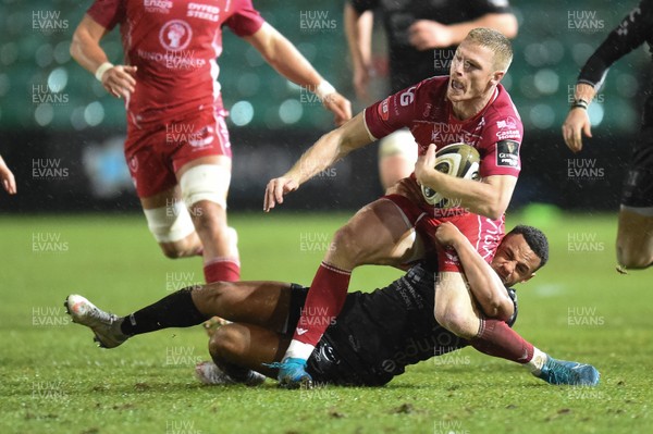 211219 - Dragons v Scarlets - Guinness Pro 14 - Johnny McNicholl of Scarlets is tackled buy Ashton Hewitt of Dragons
