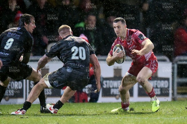 211219 - Dragons v Scarlets - Guinness Pro 14 - Gareth Davies of Scarlets is tackled by Ross Moriarty of Dragons