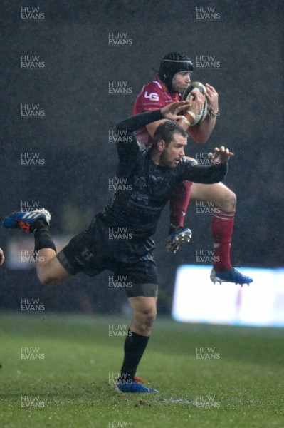 211219 - Dragons v Scarlets - Guinness Pro 14 - Leigh Halfpenny of Scarlets beats Adam Warren of Dragons to he high ball