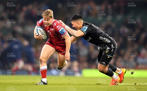 220423 - Dragons v Scarlets - United Rugby Championship - Sam Costelow of Scarlets is tackled by Sio Tomkinson of Dragons