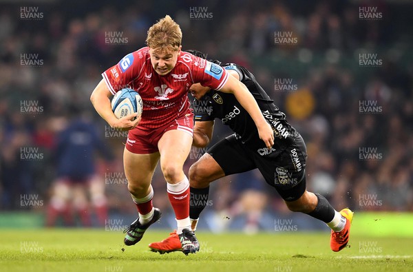 220423 - Dragons v Scarlets - United Rugby Championship - Sam Costelow of Scarlets is tackled by Sio Tomkinson of Dragons