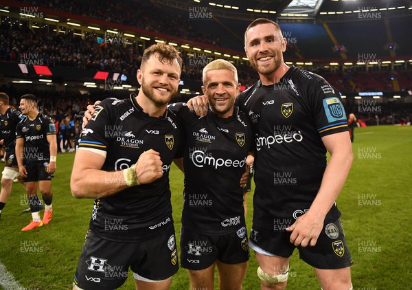 220423 - Dragons v Scarlets - United Rugby Championship - Steff Hughes, Lewis Jones and George Nott of Dragons celebrate at the end of the game
