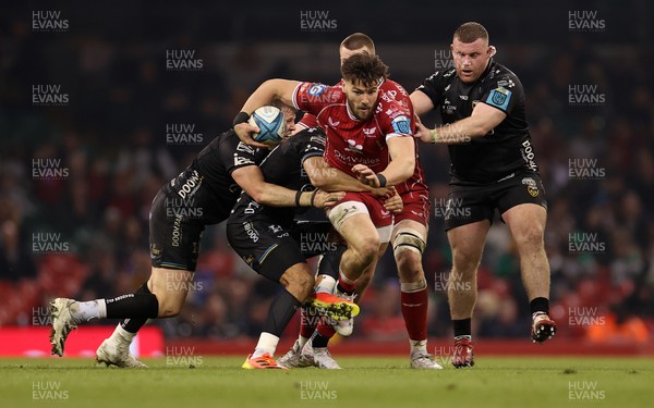 220423 - Dragons v Scarlets - United Rugby Championship - Judgement Day - Johnny Williams of Scarlets is tackled by Sio Tomkinson and Elliot Dee of Dragons 