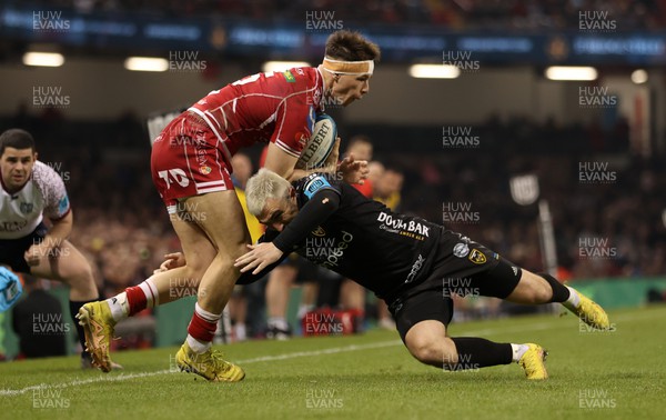 220423 - Dragons v Scarlets - United Rugby Championship - Judgement Day - Tom Rogers of Scarlets is tackled by Jordan Williams of Dragons 
