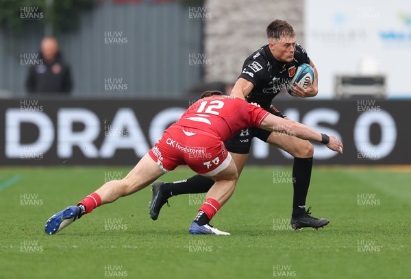 230422 - Dragons v Scarlets, United Rugby Championship - Jared Rosser of Dragons takes on Johnny Williams of Scarlets
