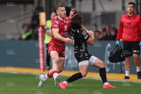 230422 - Dragons v Scarlets, United Rugby Championship - Gareth Davies of Scarlets catches Gonzalo Bertranou of Dragons with a high challenge