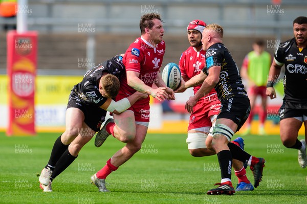 230422 - Dragons v Scarlets - United Rugby Championship - Ryan Elias of Scarlets  is tackled by Jack Dixon of Dragons and Ben Fry of Dragons