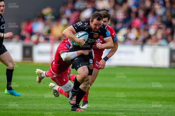 230422 - Dragons v Scarlets - United Rugby Championship - Adam Warren of Dragons is tackled by Rhys Patchell of Scarlets 