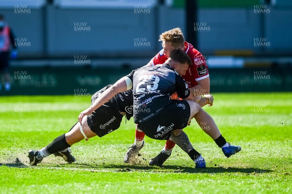 250421 Dragons v Scarlets, Guinness PRO14 Rainbow Cup - Sam Costelow of Scarlets tackled by Jack Dixon of Dragons
