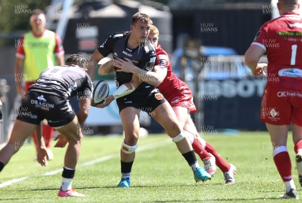 250421 Dragons v Scarlets, Guinness PRO14 Rainbow Cup - Taine Basham of Dragons looks for support as he is tackled