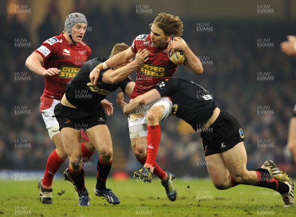 300313 - Newport-Gwent Dragons v Scarlets - RaboDirect PRO12 - Liam Williams of Scarlets is tackled by Patrick Leach and Jack Dixon of Newport-Gwent Dragons 