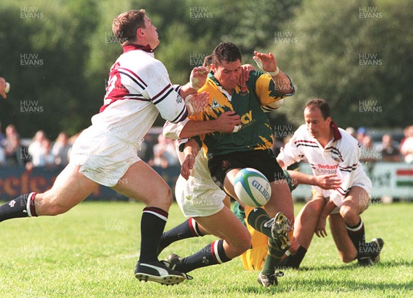 140996 - Dunvant v Swansea - Mark Sutton of Dunvant is tackled by Mark Taylor and Scott Gibbs (Left)