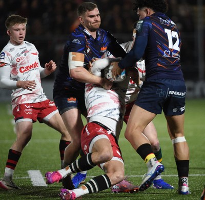 270226 - Edinburgh Rugby v Scarlets - United Rugby Championship - Tomi Lewis of Scarlets is tackled by James Lang (L) and Mosese Tuipulotu of Edinburgh 