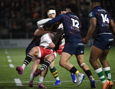 270226 - Edinburgh Rugby v Scarlets - United Rugby Championship - Tomi Lewis of Scarlets is tackled by James Lang (L) and Mosese Tuipulotu of Edinburgh