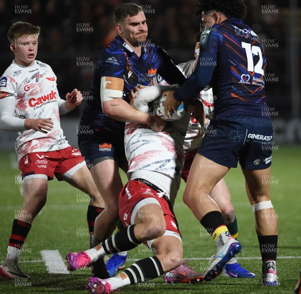 270226 - Edinburgh Rugby v Scarlets - United Rugby Championship - Tomi Lewis of Scarlets is tackled by James Lang (L) and Mosese Tuipulotu of Edinburgh 