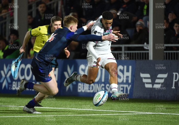 010324 - Edinburgh v Ospreys - United Rugby Championship - Keelan Giles of Ospreys chips ahead as he is tackled by Harry Paterson of Edinburgh winger