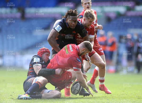 270221 - Edinburgh Rugby v Scarlets - Guinness PRO14 - Morgan Jones of Scarlets is tackled by Grant Gilchrist and Bill Mata